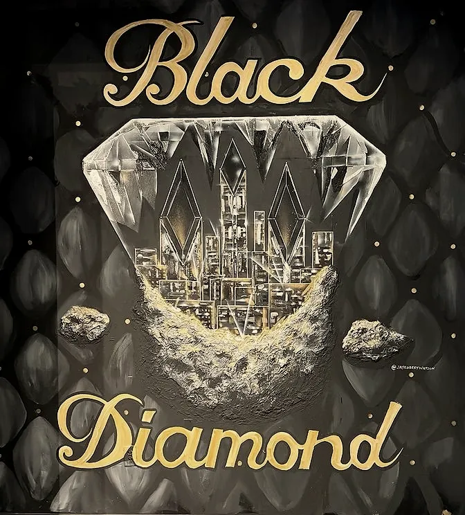 The Black Diamond mural: gold script over a crystal diamond holding the Charlotte skyline